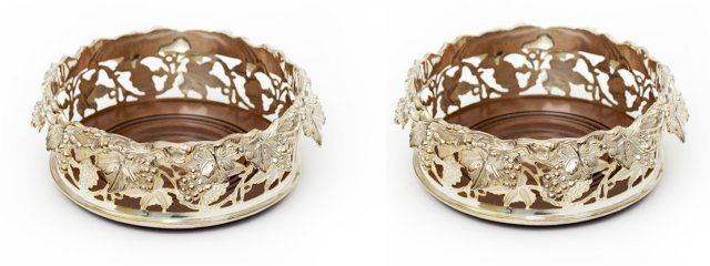 Pair of silver plated wine bottle coasters: With grapevine decorated siding. Approx. 7" D. Good condition.