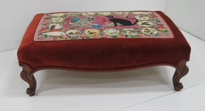 Oversized ottoman with carved legs: Needlepoint top depicting cat & dog. Approx. 14" H x 30" x 45". Some losses.