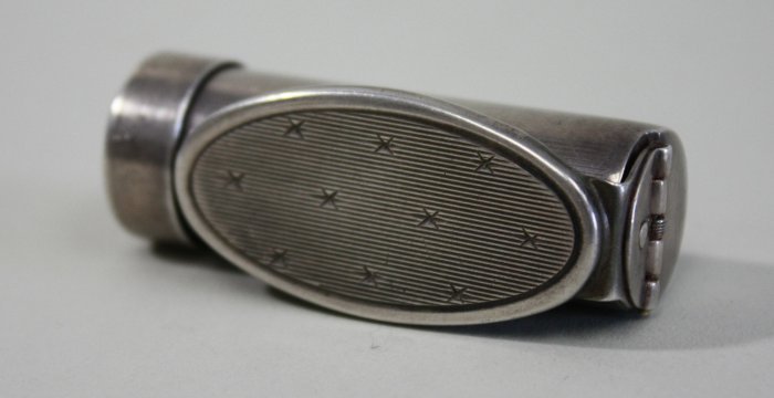 Sterling silver lipstick case: With flip top mirror. Stamped 925. Approx. 4" L open, 2 1/8" L closed. Approx. 1 ozt.