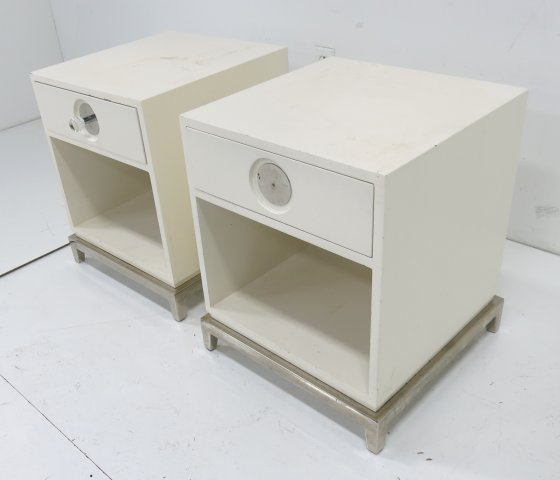 Jonathan Adler pair of bedside tables: White lacquered. Labeled. Approx. 22" H x 18" W x 18" D. Finish worn. Scratched. Some paint chipping. Missing 1 pull.
