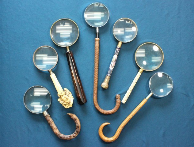 7 Magnifying Glasses: Porcelain & brass. Largest approx. 16" H, with bone handle. From a NYC collector's 40 year compilation. Crack to porcelain handle. French head is molded. Bone handle is broken off at end.