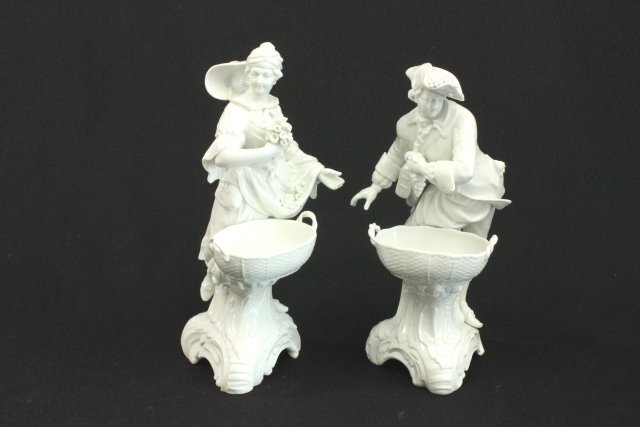 Pair of KPM White Porcelain Figures: Man and woman with baskets. Approx. 8 1/2" H. Fingers missing on woman.
