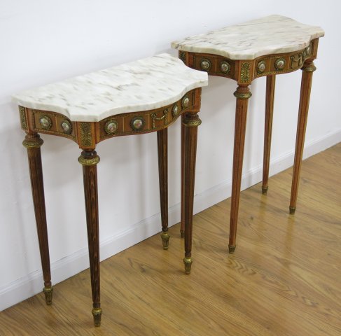 Pair Louis XVI style Marble Top Console Tables: Serpentine front with porcelain plaques & brass mounts. Late 20th century. Approx. 31" H x 23" W x 12 3/4" D.
