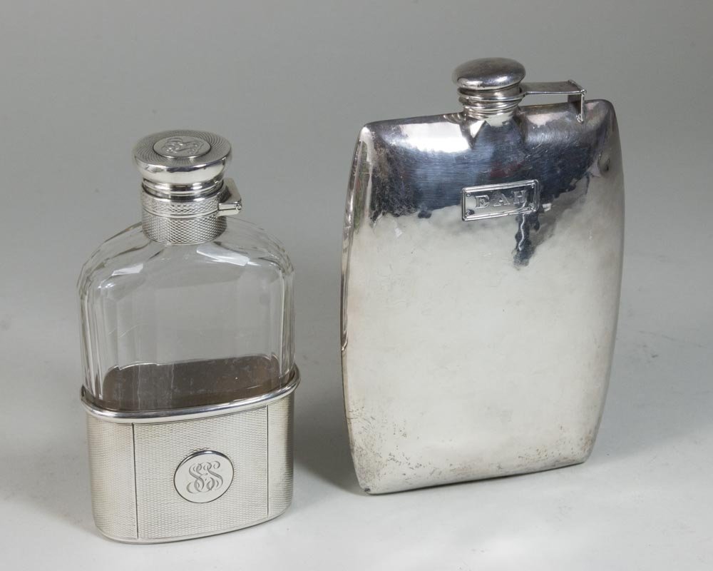 2 Sterling Silver Flasks: One by Garrod, initialled, approx. 5" H x 5 7/8" W. One handhammered English silver with crystal insert.
