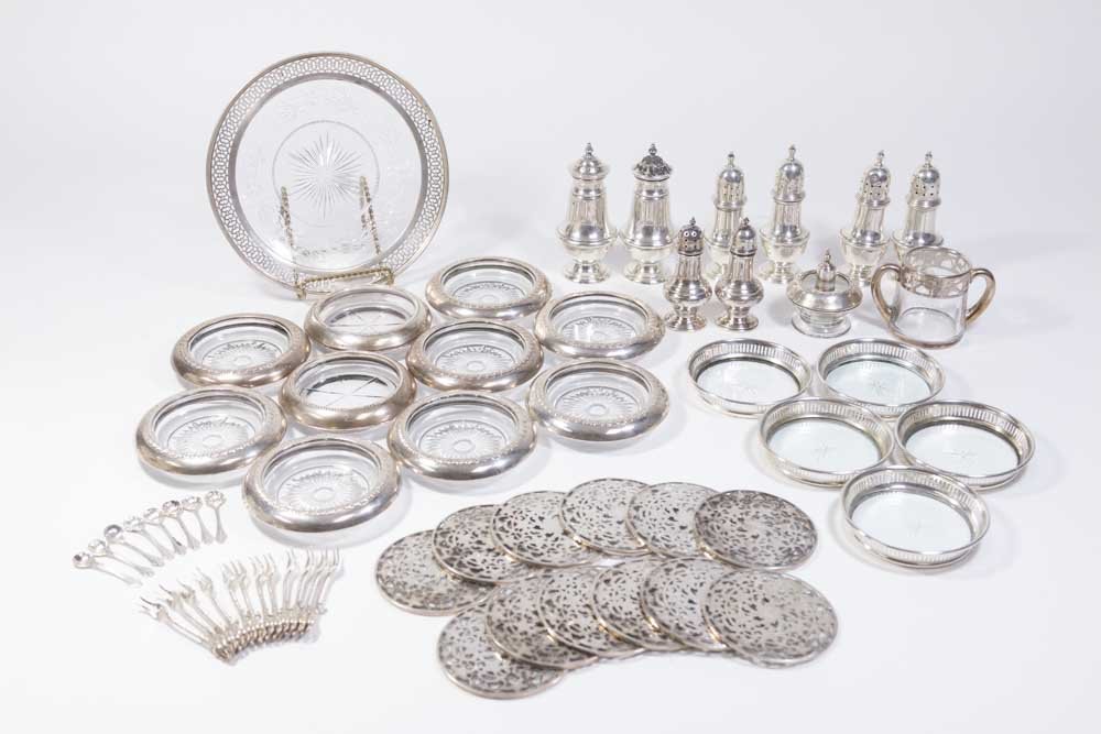 Group Lot of Sterling Silver Items: Including 15 sterling silver and glass coasters, 12 small trivets with glass, glass dish with sterling rim, 8 pairs of salt & pepper shakers, small lighter, double handle glass sterling overlay cup, 1