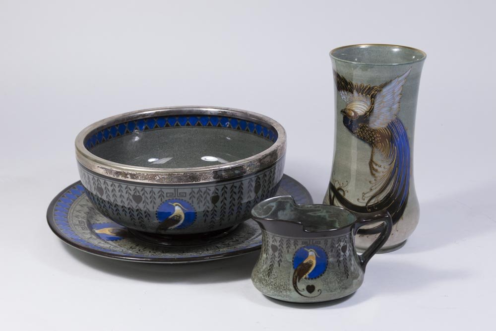 4 Pieces Royal Doulton Titanium: Bowl, vase, creamer, dish. With birds of paradise motif. Vase approx. 7 1/4" H. Bowl approx. 3 3/4" H x 8" D. Dish approx. 10 1/2" D.