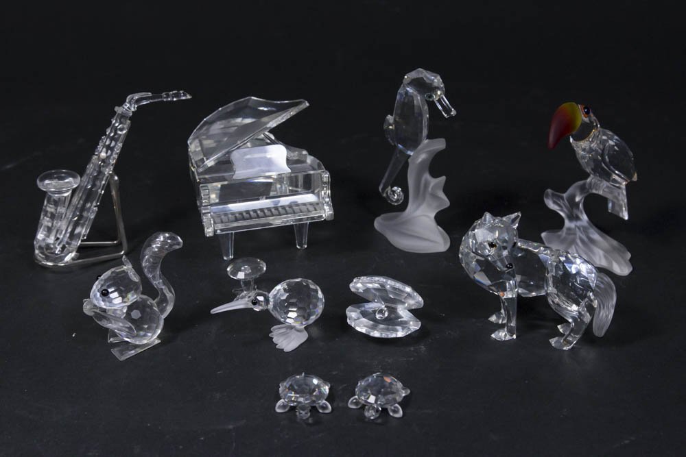 10 Swarovski Sculptures in Original Boxes: Including saxophone, seahorse, piano with bench, dog, cockatoo, clam, squirrel, bird, and 2 turtles. In original boxes.