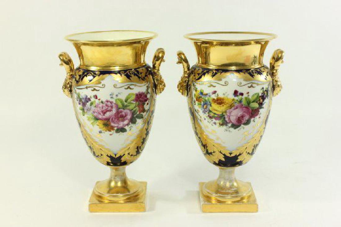 :Pair Gilt Cobalt Ground Paris Porcelain Urns: Late 19th century. Signed Ed Honore a Paris. Decorated with flowering swags. Approx. 11 3/4" H. (5252) Flake between base and body. 1 rim repaired. Wear to gold wash.