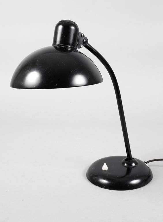 Schreibtischlampe Kaiser Idell: um 1930, Schirm gemarkt Original Kaiser Idell, beschwerter Rundfuß mit an Kugelgelenk neigbarem, leicht geschwungenem Leuchterarm sowie variabel arretierbarem Halbkugelschirm aus schwarz gefasstem We