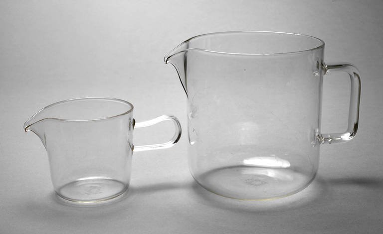 Wilhelm Wagenfeld Saucer und Milchtopf: Entwurf 1931 für die Jenaer Glaswerke Schott & Gen., Saucer mit Fünfeckmarke und Schriftzug "Jenaer Glas Soser", Milchtopf mit Firmenmarke Schott & Gen. und Bezeichnung 1 L, klares feuerfestes Glas,
