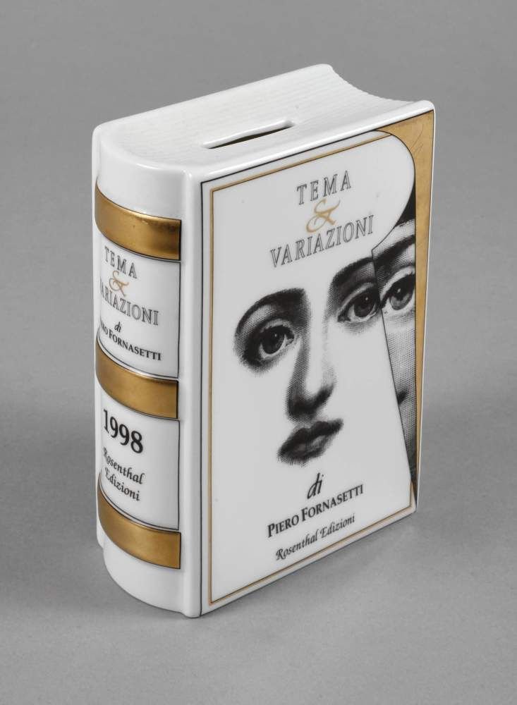 Rosenthal Spardose Piero Fornasetti: aus einer limitierten Kunstreihe 1998, goldene Stempelmarke Classic Germany, schwarz und gold bedruckt, als Buch gestaltet, Plastikverschluss am Boden, H 16 cm.