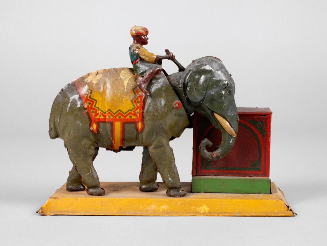 Hans Eberl Damo als Elefant mit Drehorgel: um 1930, ungemarkt, Blech farbig lithogr., plastischer Elefant mit aufsitzendem Mahut und beweglich gelagertem Kopf, mit seinem Rüssel die Drehorgel mit integrierter Spieldose drehend, Alters- und Ge