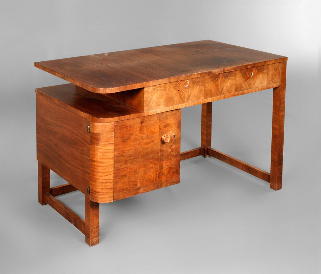 Schreibtisch: deutsch, um 1830, Nussbaummaser furniert, asymmetrisch gestalteter Tisch mit Tür und zwei Schubkästen, Oberfläche mit Gebrauchsspuren, das Schloss einer Schublade fehlt, Maße 74 x 119 x 64 cm.