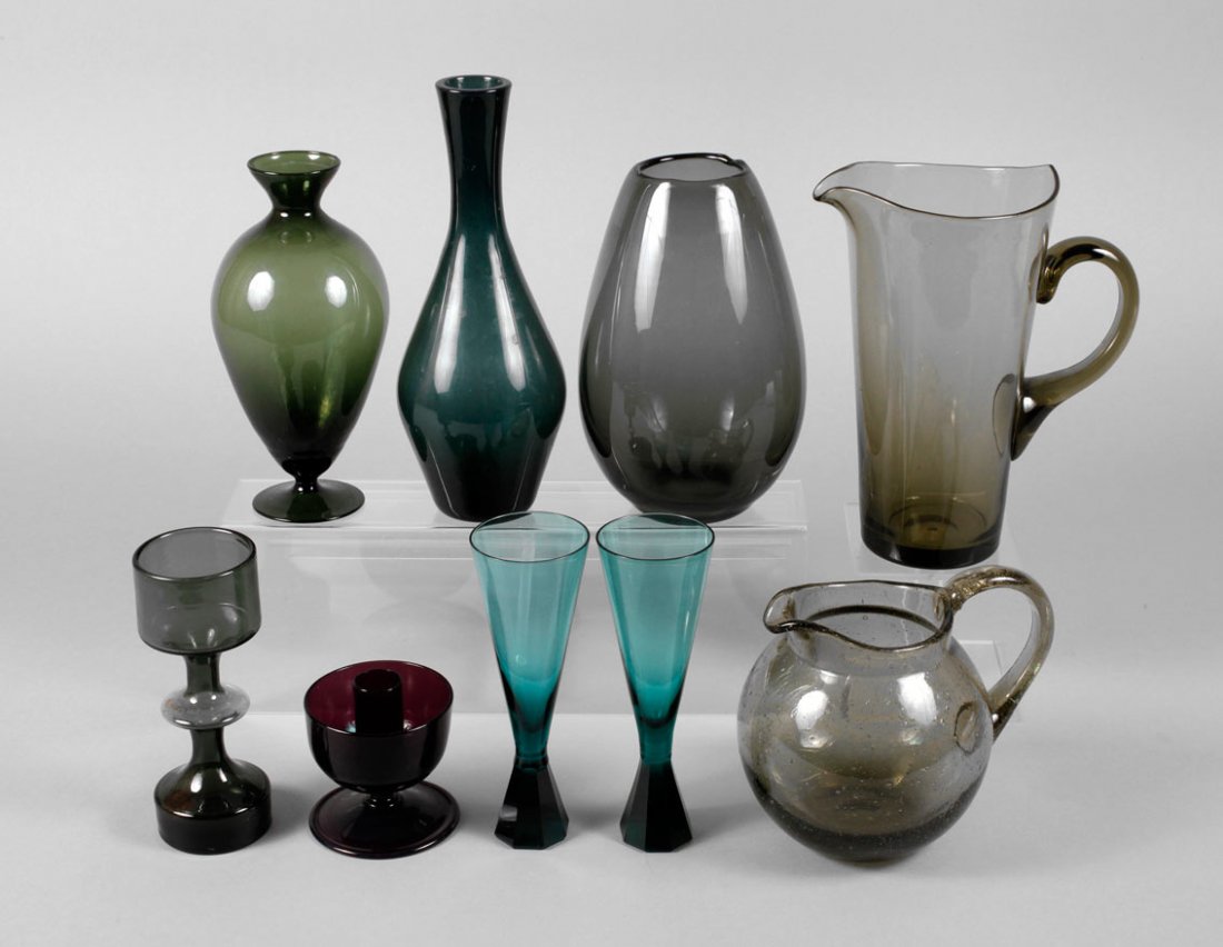Neun Glasobjekte: 1960er bis 1980er Jahre, aus rauchgrauem, blauem und violettem Glas, drei Becher, ein Kerzenleuchter, zwei Kannen und drei Vasen, ein Becher unleserlich signiert, eine Vase mit stärkeren Gebrauchsspu
