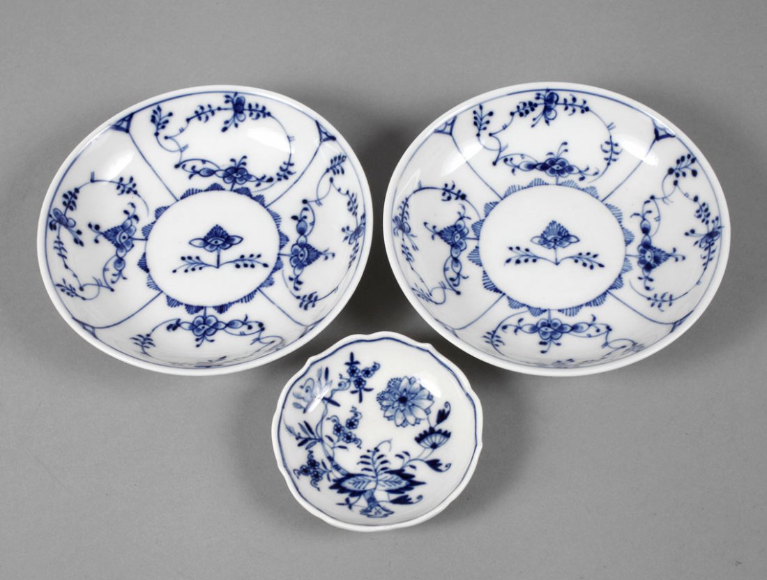 KPM Berlin/Meissen drei Teile Blaumalerei: zwei Untertassen KPM Berlin, 19. Jh., mit gepinselten Nummern XVI, die andere unleserlich, Strohblumendekor in kobaltblauer Unterglasurbemalung, dazu ein Schälchen Meissen, zweimal gestrichen mit Zwi