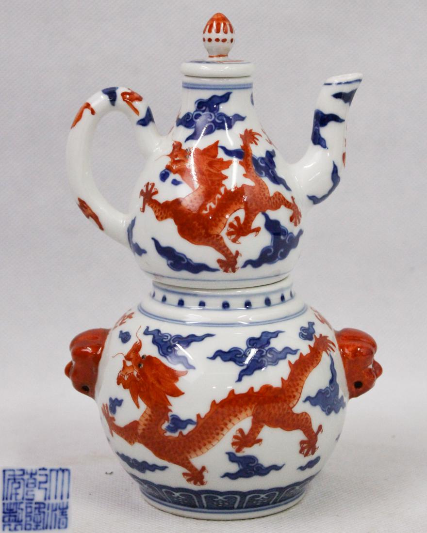 DAQING QIANLONG NIANZHI MARK DOUBLE-GOURD EWER: With DaQing QianLong NianZhi mark. The ewer is decorated with floating dragons among clouds in colors of blue and red. Height 7.08 in Width 4.92 in