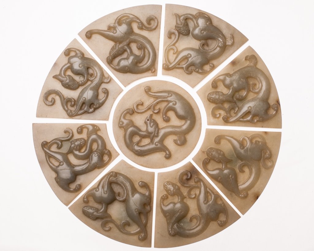 Nine-Piece Sectional Jade Disc: Nine-Piece Sectional Jade Disc, 19th century, China. Nine pieces carved with ChiLong in relief. Stone of a gray celadon color. L 3.5 in each. D 8.25 in disc. 九片龍形雕&#