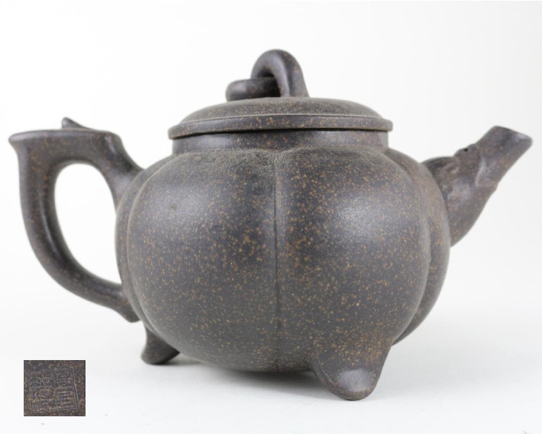 JIANGLIPING ZHI MARK ZISHA TEAPOT: With JiangLiPing Zhi mark. The zisha teapot is finely carved with a melon shape. supported with three short everted feet. Dimension 6.625 in x 2.375 in