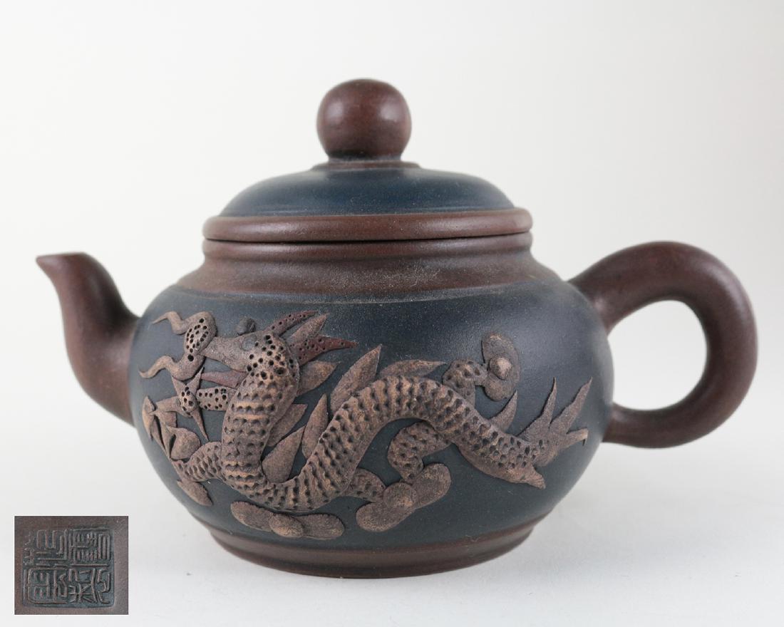 XUEYUN ZHI MARK ZISHA TEAPOT: With XueYun Zhi mark. The zisha teapot is decorated with a dragon pattern on the exterior. Dimension 4 in x 2.875 in