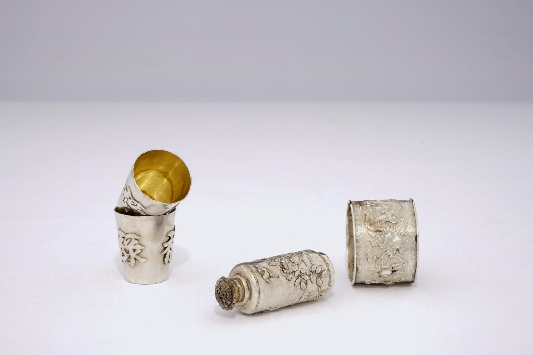 A pair of Chinese silver wine cups, a shaker and a: A pair of Chinese silver wine cups, a shaker and a napkin ring, 19/20th C. Dia.: 3,5 - H.: 4 cm (the cups)H.: 7 cm (the shaker)Dia.: 4,5 cm - W.: 3,5 cm (the napkin ring) The sprinkler marked on the b