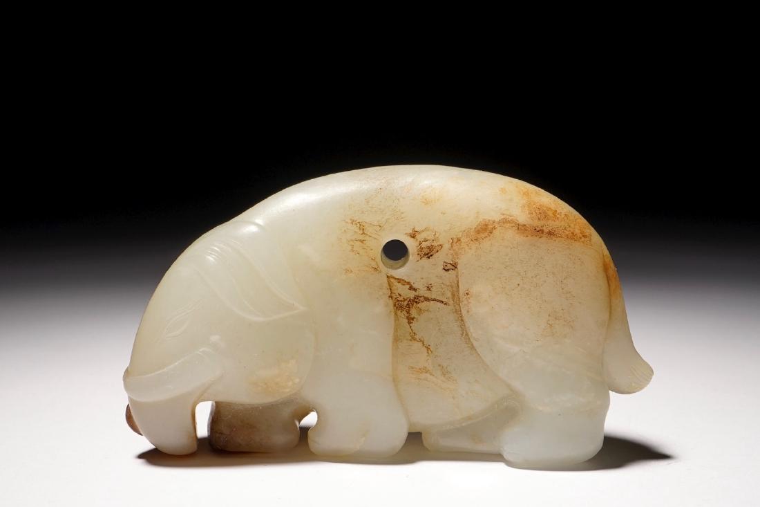 A mottled jade carving of an elephant, 19th C.: A mottled jade carving of an elephant, 19th C. Dim.: 4,3 x 7,5 x 2 cm Pierced for hanging as a pendant.