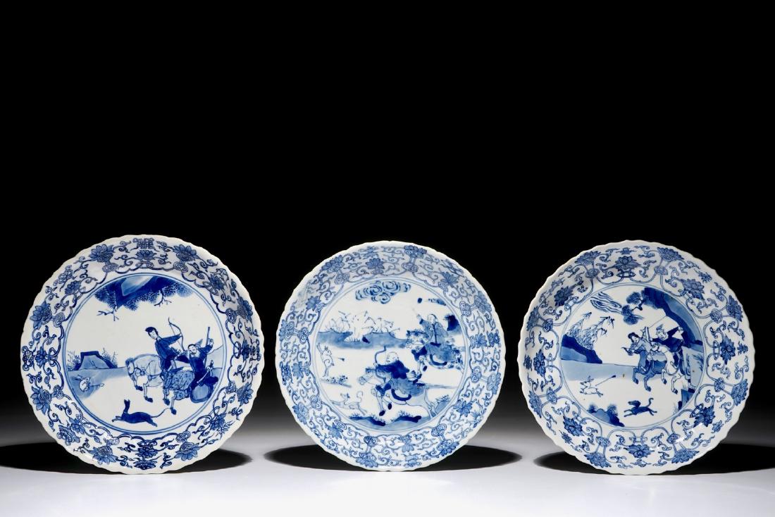 Three Chinese blue and white fluted plates with a: Three Chinese blue and white fluted plates with a Mongolian hunting scene, Chenghua marks, Kangxi Dia.: 20 cm