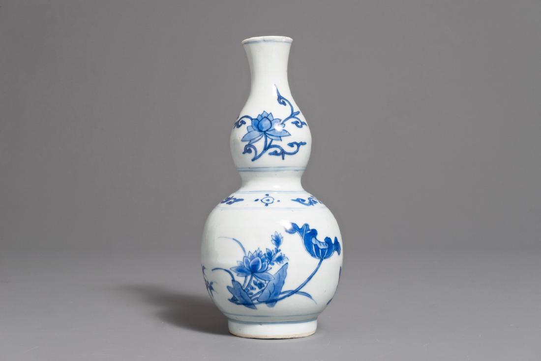 A Chinese blue and white double gourd vase with floral: A Chinese blue and white double gourd vase with floral design, Transitional period H.: 20 cm We have more lots available exclusively on our website www.rm-auctions.com! Condition reports and high reso