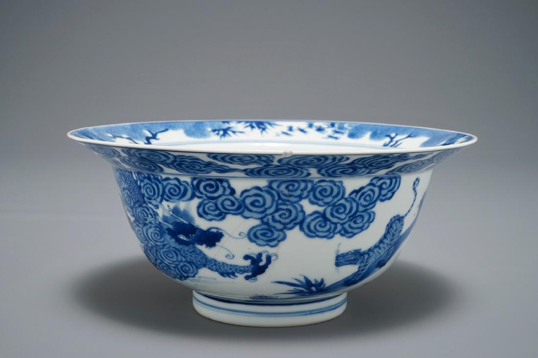 A Chinese blue and white klapmuts bowl with a tiger: A Chinese blue and white klapmuts bowl with a tiger fighting a dragon, Chenghua mark, Kangxi H.: 9,5 cm - Dia.: 21,5 cm We have more lots available exclusively on our website www.rm-auctions.com! Cond