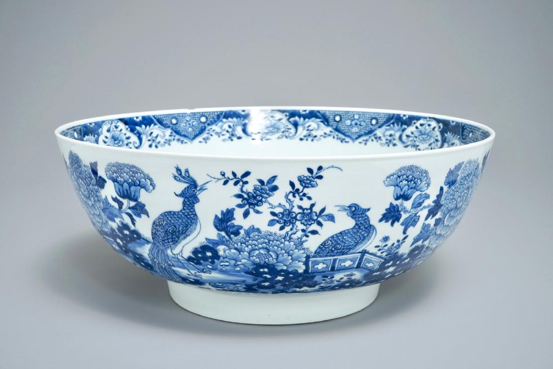 A large Chinese blue and white bowl with birds among: A large Chinese blue and white bowl with birds among blossoming flowers, Qianlong Dia.: 40 cm - H.: 16,5 cm Condition: (UV checked)- With two 10 cm hairlines from the rim, as well as a chip, mostly on