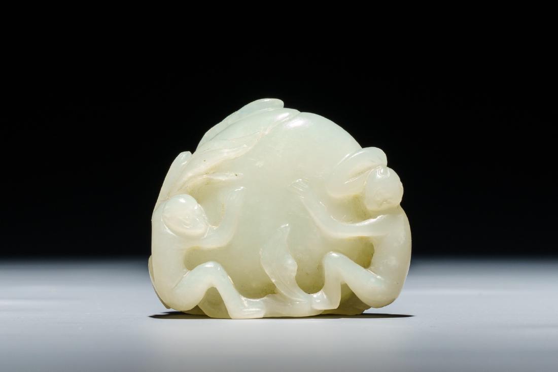 A Chinese celadon jade carving of a peach with two: A Chinese celadon jade carving of a peach with two monkeys, 19/20th C. ---- H.: 4,5 cm