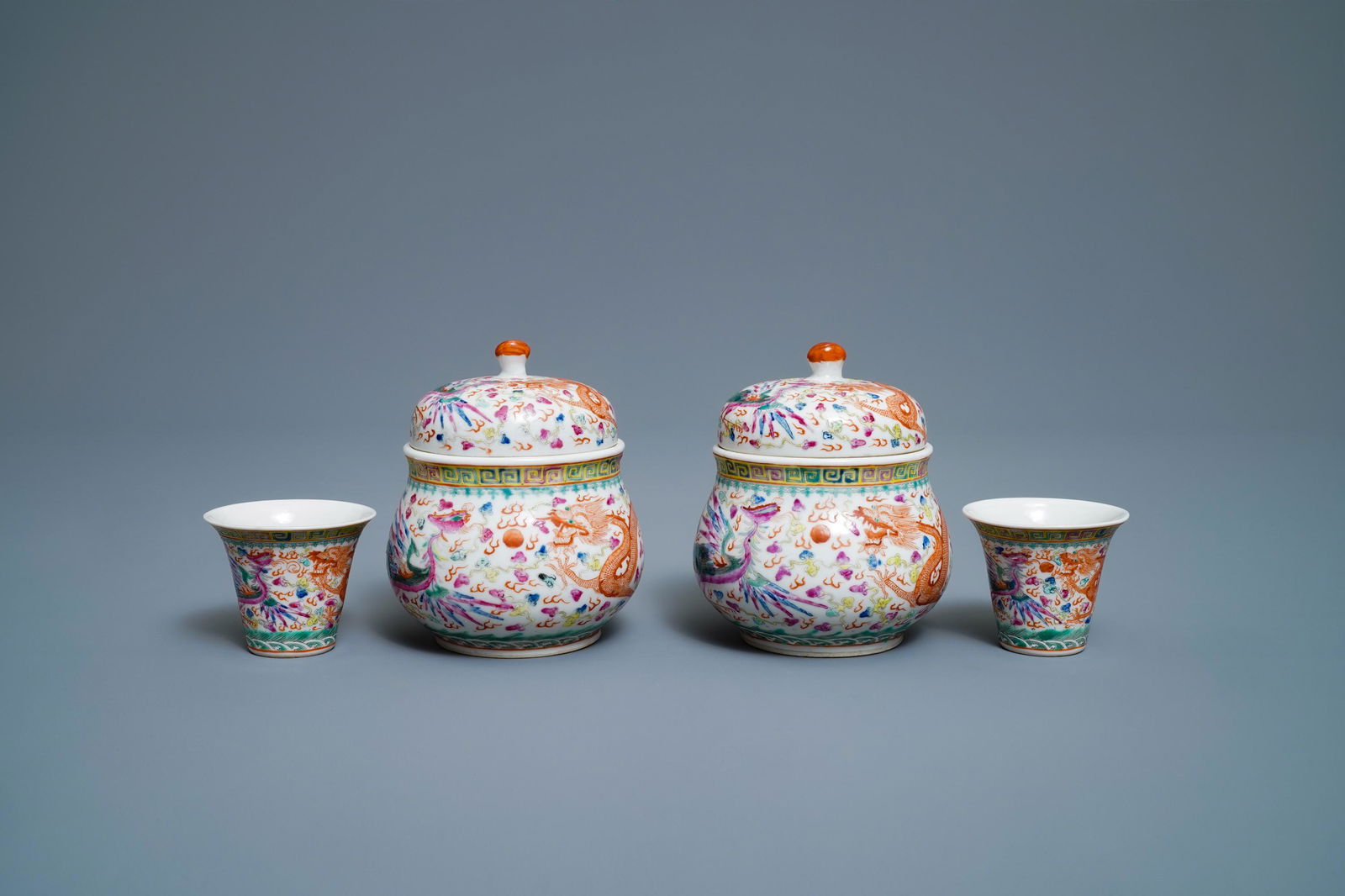 A pair of Chinese famille rose wine cups and warmers: A pair of Chinese famille rose wine cups and warmers with dragons and phoenixes, seal mark, 19/20th C. -- H.: 10,5 cm - Dia.: 8,5 cm (the warmers)