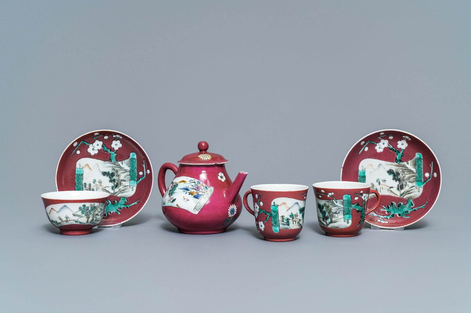 A Chinese famille rose ruby-ground teapot, three cups: A Chinese famille rose ruby-ground teapot, three cups and two saucers, Yongzheng -- L.: 15,5 cm - H.: 11,5 cm (the teapot) L.: 9 cm H.: 6 cm (the cups with handles) Dia.: 8,5 cm - H.: 5 cm (the cup) D