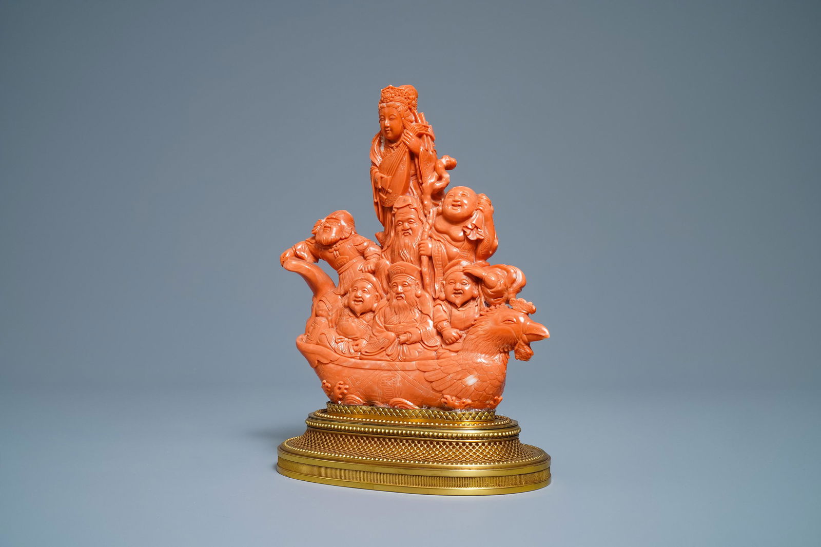 A Japanese carved red coral group of the seven lucky: A Japanese carved red coral group of the seven lucky gods on a phoenix boat, Meiji, 19th C. -- H.: 26,5 cm (incl. stand)Â Weight: 2713 gr.