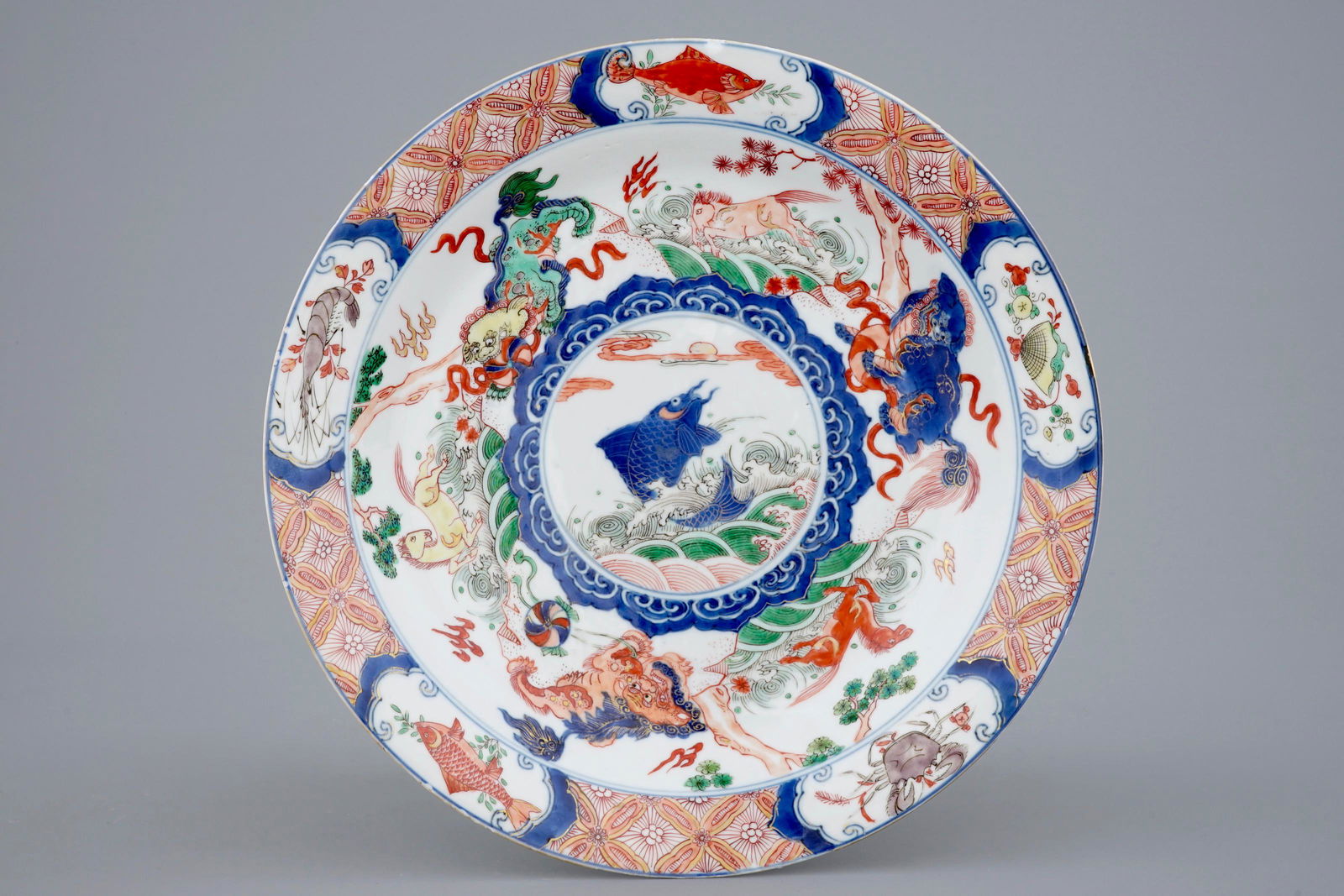 A Chinese famille verte dish with a carp surrounded by: A Chinese famille verte dish with a carp surrounded by horses and buddhist lions, Kangxi Dia.: 27 cmÂ Marked on the back with a 'Fu' mark in double circle.Â Ref.: - Christie's, Fine Chinese Cera