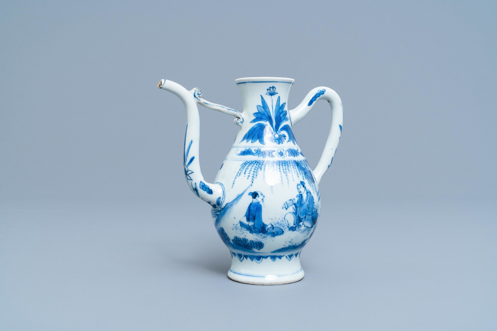 A Chinese blue and white ewer with figures in a: A Chinese blue and white ewer with figures in a landscape, Transitional period L.: 18,5 cm - H.: 18 cm
