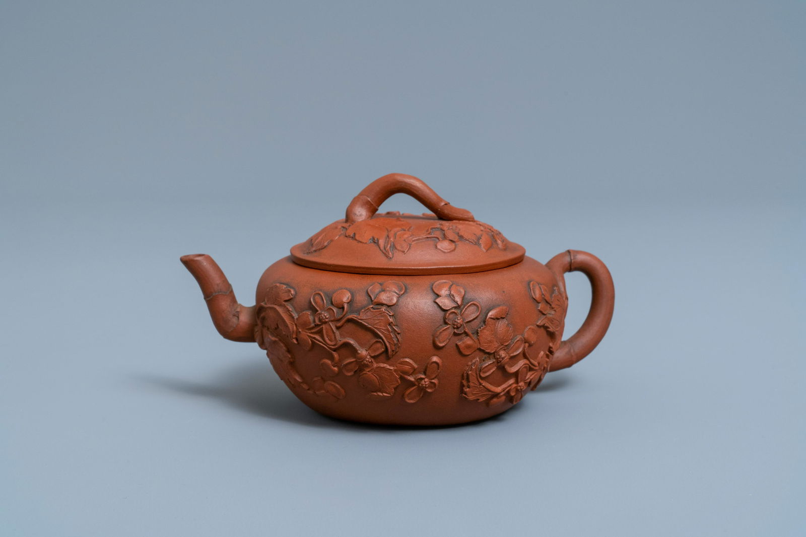 A Chinese Yixing stoneware teapot and cover with: Full title: A Chinese Yixing stoneware teapot and cover with applied floral design, Kangxi Description: L.: 17,5 cm - H.: 9 cm