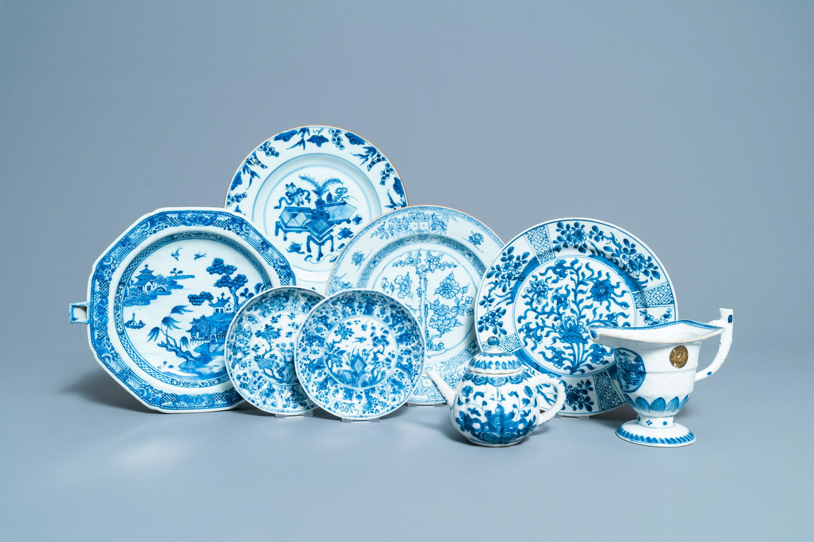 Six Chinese blue and white dishes, a teapot and a: Full title: Six Chinese blue and white dishes, a teapot and a helmet-shaped jug, Kangxi and later Description: L.: 27 cm (the warming dish) Dia.: 14 cm (the pair of small plates) L.: 16,5 - H.: 13 cm