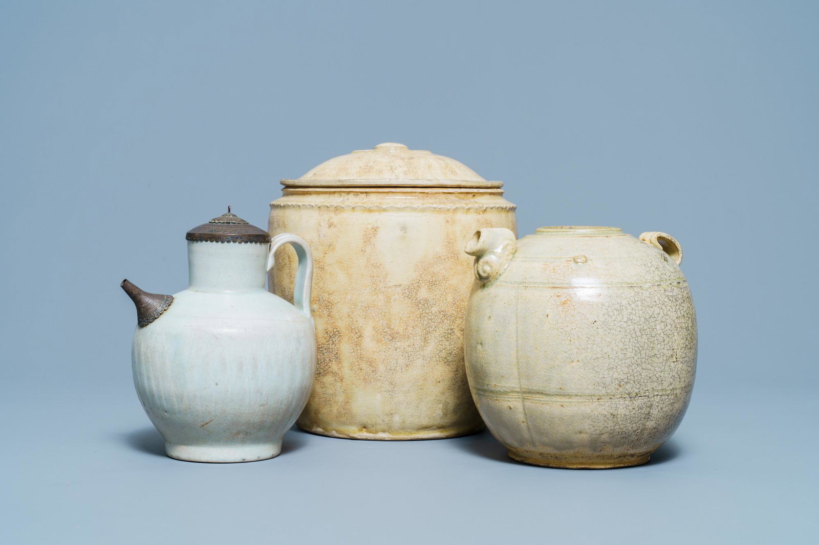 A Chinese celadon-glazed 'Jue' ewer, a qingbai-glazed: Full title: A Chinese celadon-glazed 'Jue' ewer, a qingbai-glazed wine ewer and a storage vessel, Song/Yuan Description: H.: 23 cm - 18 cm - 16,5 cmÊ Provenance: A Belgian private collection, mainly 