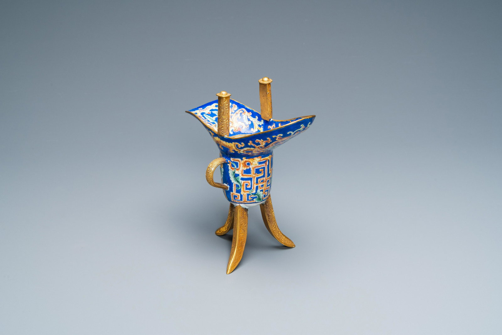 A Chinese Canton enamel and gilt bronze ritual wine: Full title: A Chinese Canton enamel and gilt bronze ritual wine vessel, 'jue', 18/19th C. Description: H.: 19 cm - L.: 17 cm The absence of a condition report does not imply that a lot is in perfect c