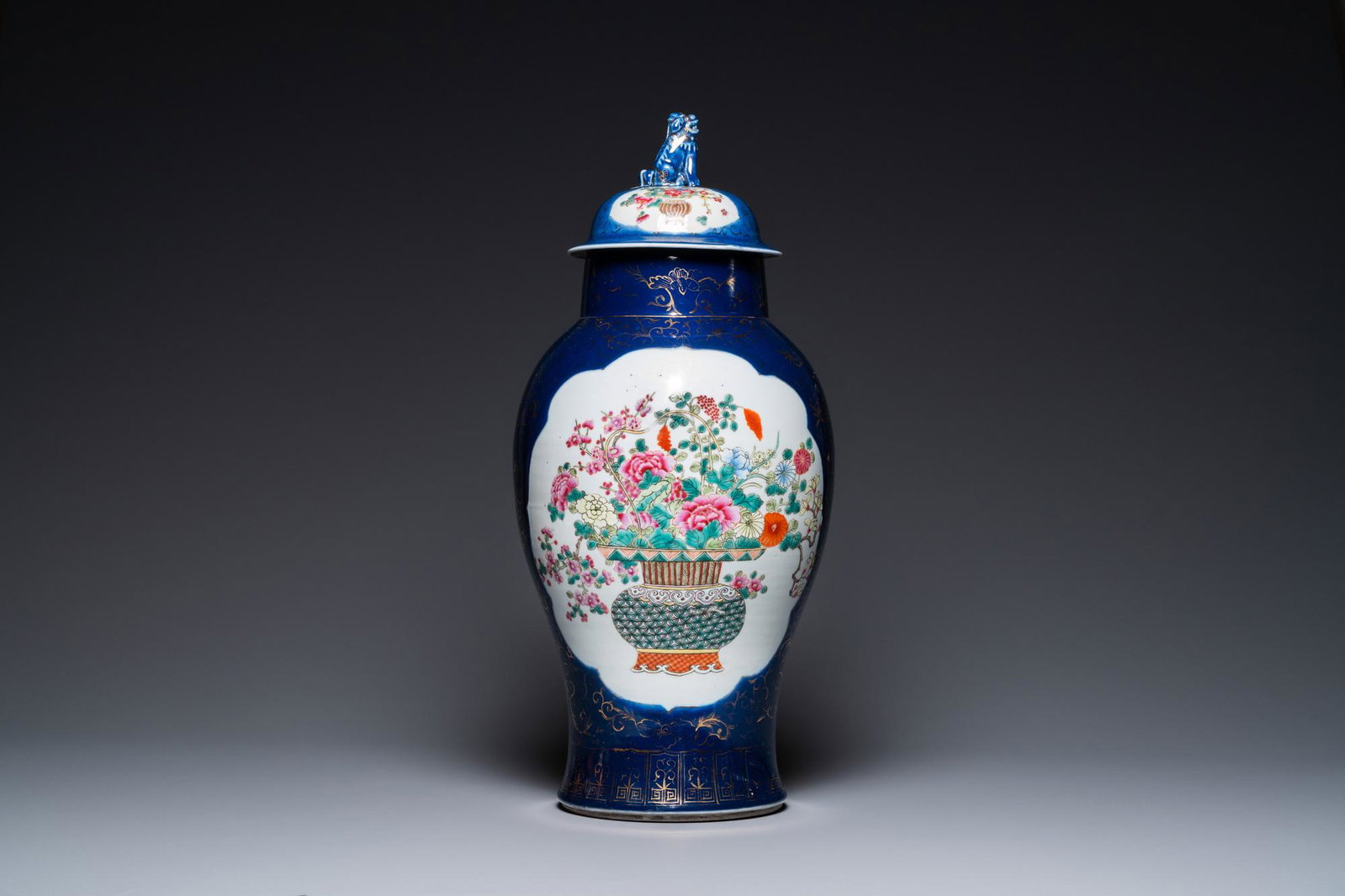 A Chinese blue-ground famille rose vase and cover, Kangxi mark, 19th C.: Full title: A Chinese blue-ground famille rose vase and cover, Kangxi mark, 19th C. Description: H.: 59 cm The absence of a condition report does not imply that a lot is in perfect condition. Please c