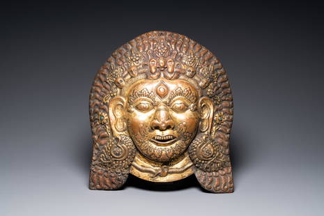 A large Tibetan gilt copper repousse mask of Bhairava, Tibet or Nepal, 19th C.: Full title: A large Tibetan gilt copper repousse mask of Bhairava, Tibet or Nepal, 19th C. Description: Dim.: 42,5 x 38,5 cm The absence of a condition report does not imply that a lot is in