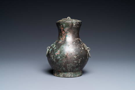 A Chinese bronze 'hu' vase and cover, Han: Full title: A Chinese bronze 'hu' vase and cover, Han Description: H.: 16,5 cm Ref.: Christie's, London, Nov. 7, 2012, for a similar but slightly smaller example. (link available on our website