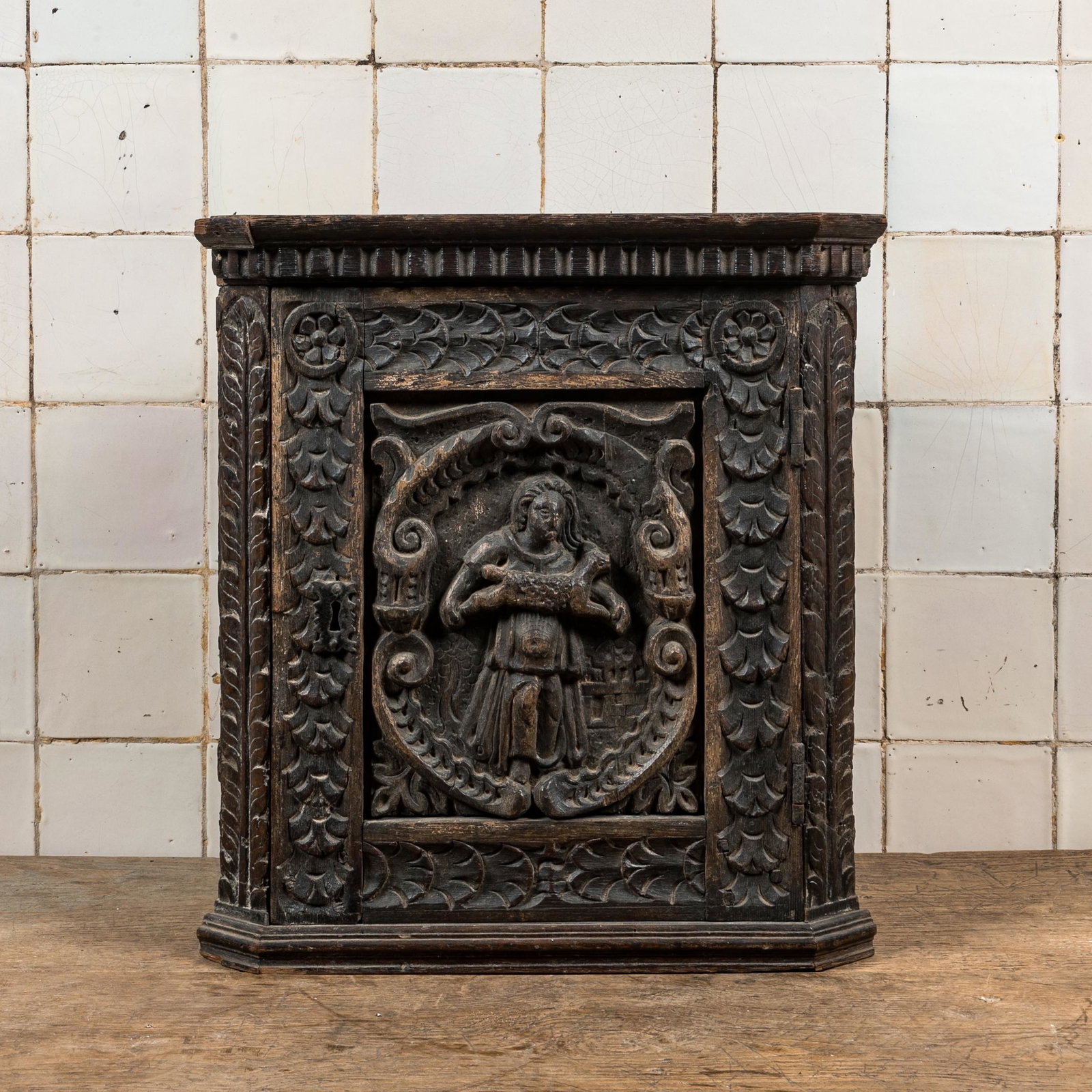 A small dark-patinated wooden corner cabinet with a shepherdess, 17th C. and later: Full title: A small dark-patinated wooden corner cabinet with a shepherdess, 17th C. and later Description: H 50 x L 45,5 x D 28 cm