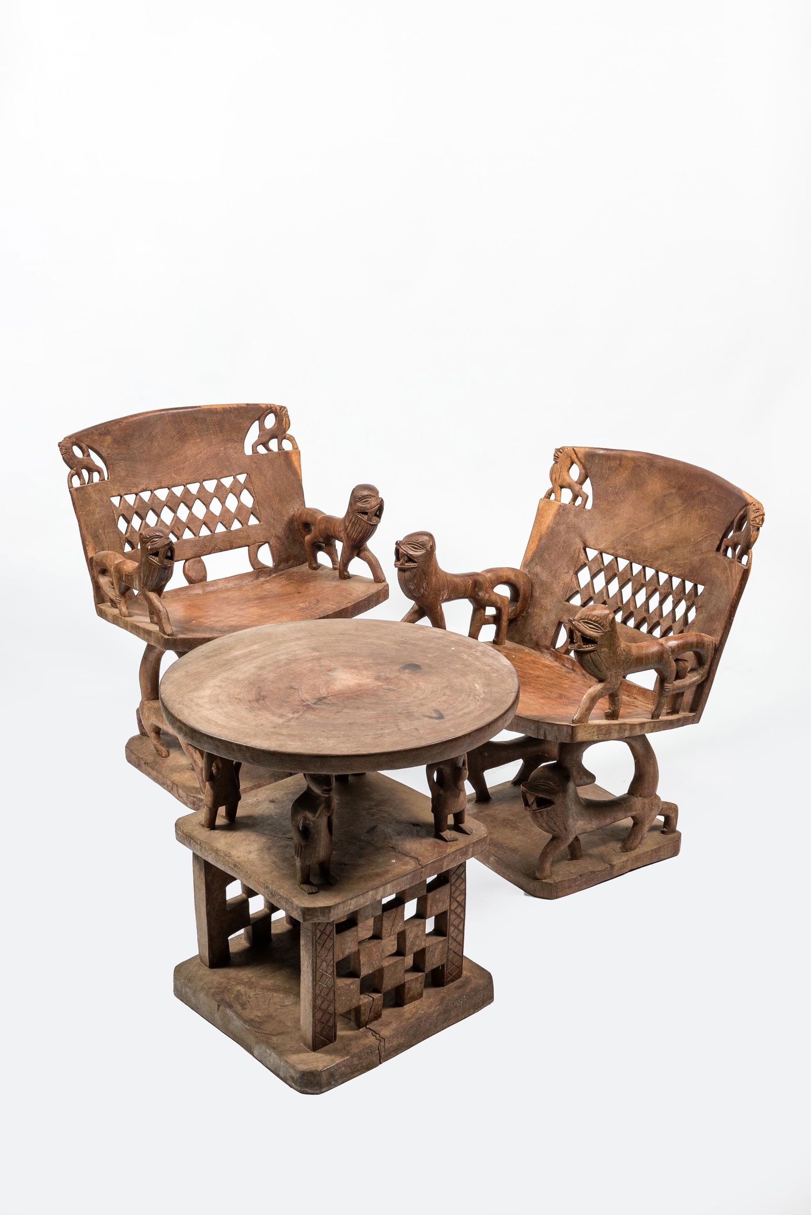 An African wooden salon set comprising two chairs and a coffee table, 20th C. (1 of 2)