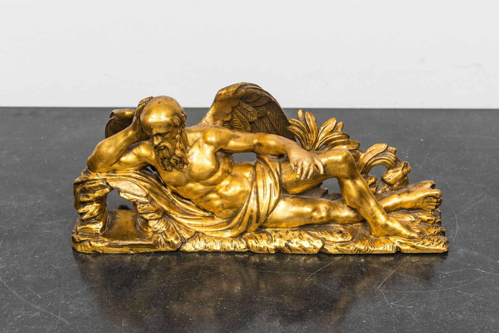 A gilt wooden sculpture of the winged Chronos, 17/18th C. (1 of 2)