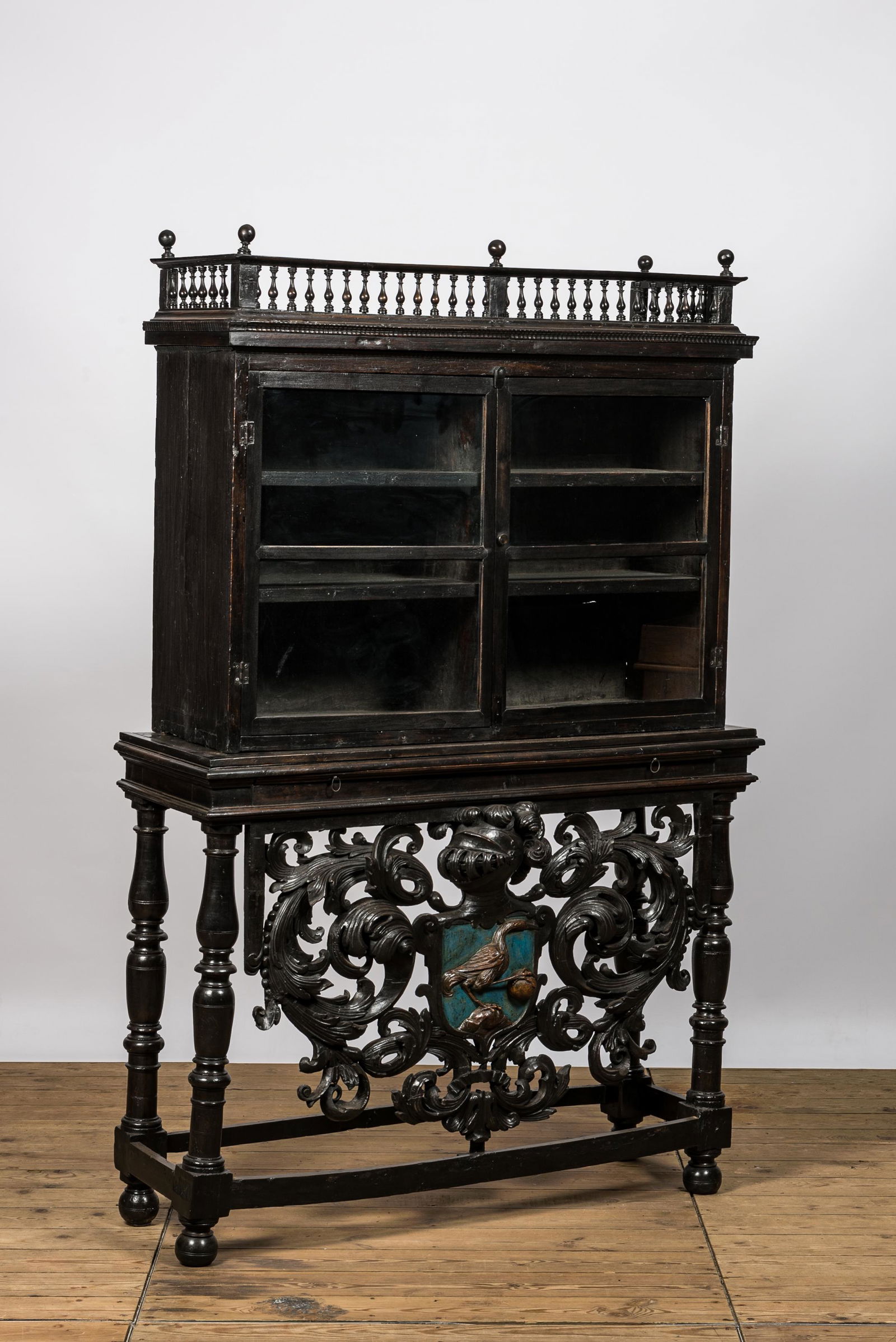 A Spanish ebonised wooden display cabinet on richly carved armorial stand, 19th C. (1 of 5)
