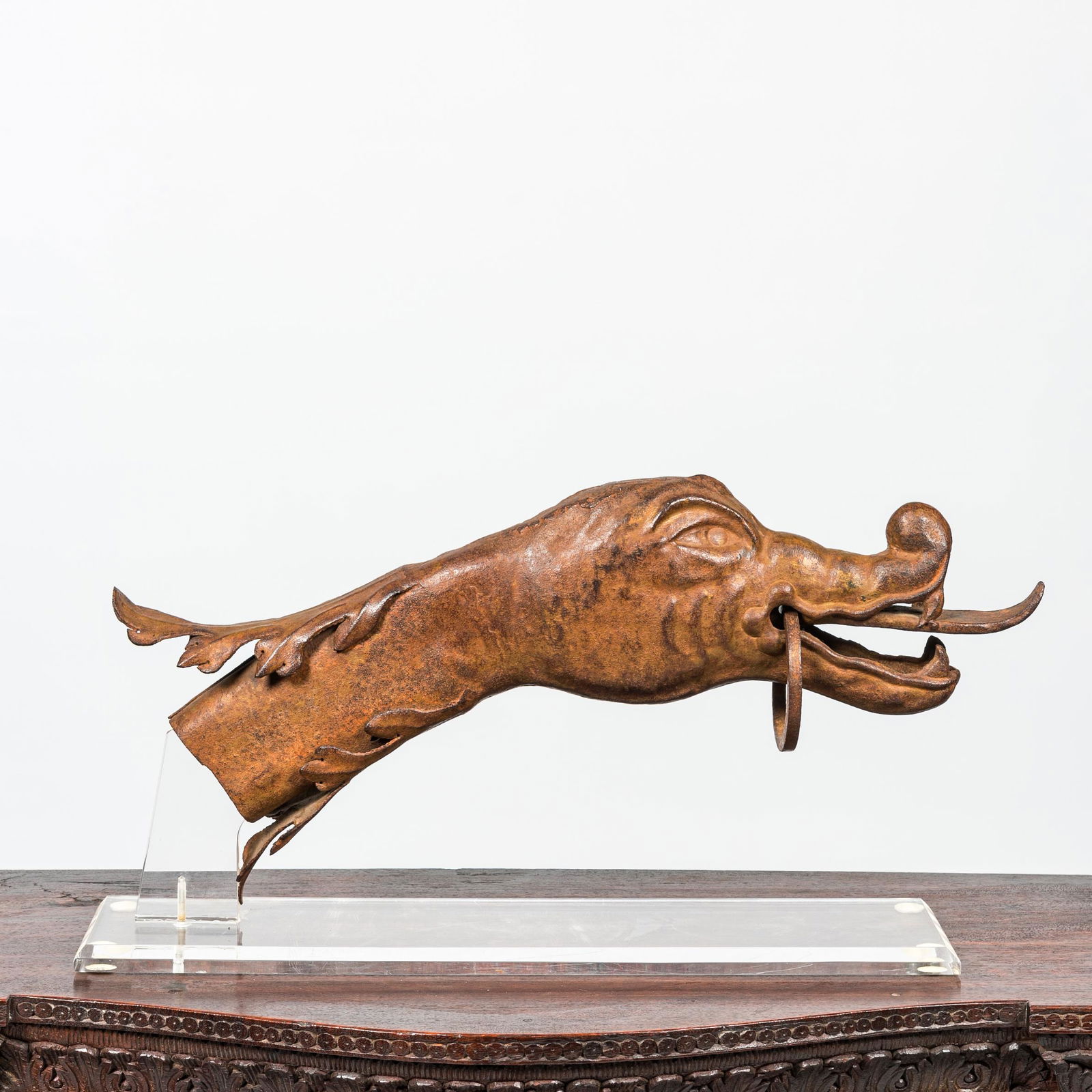 A French wrought iron dragon head ornament on a plexi base, 18/19th C. (1 of 2)