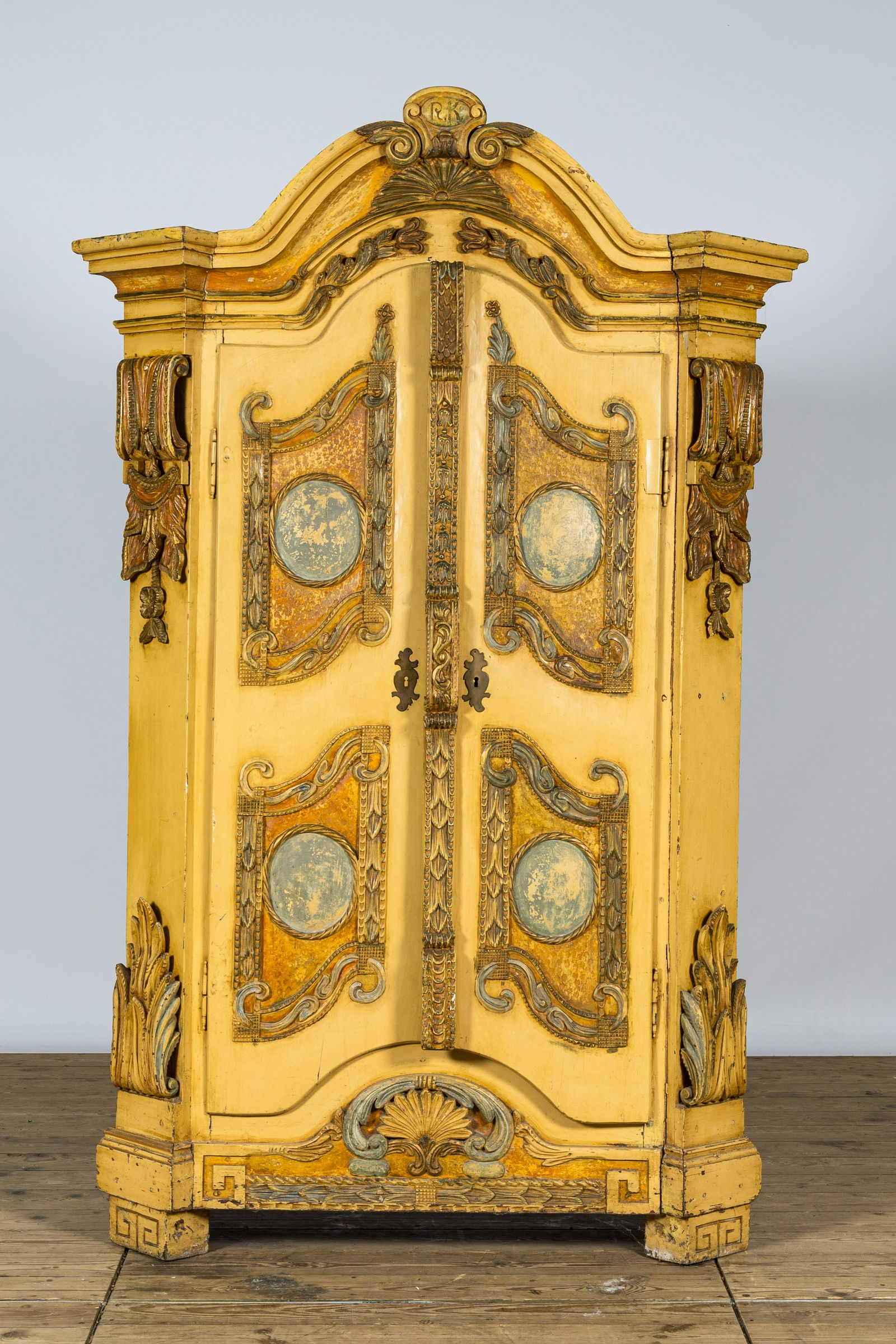 A German patinated wooden two-door cabinet with relief design and monogram R.K., 19th C. (1 of 3)