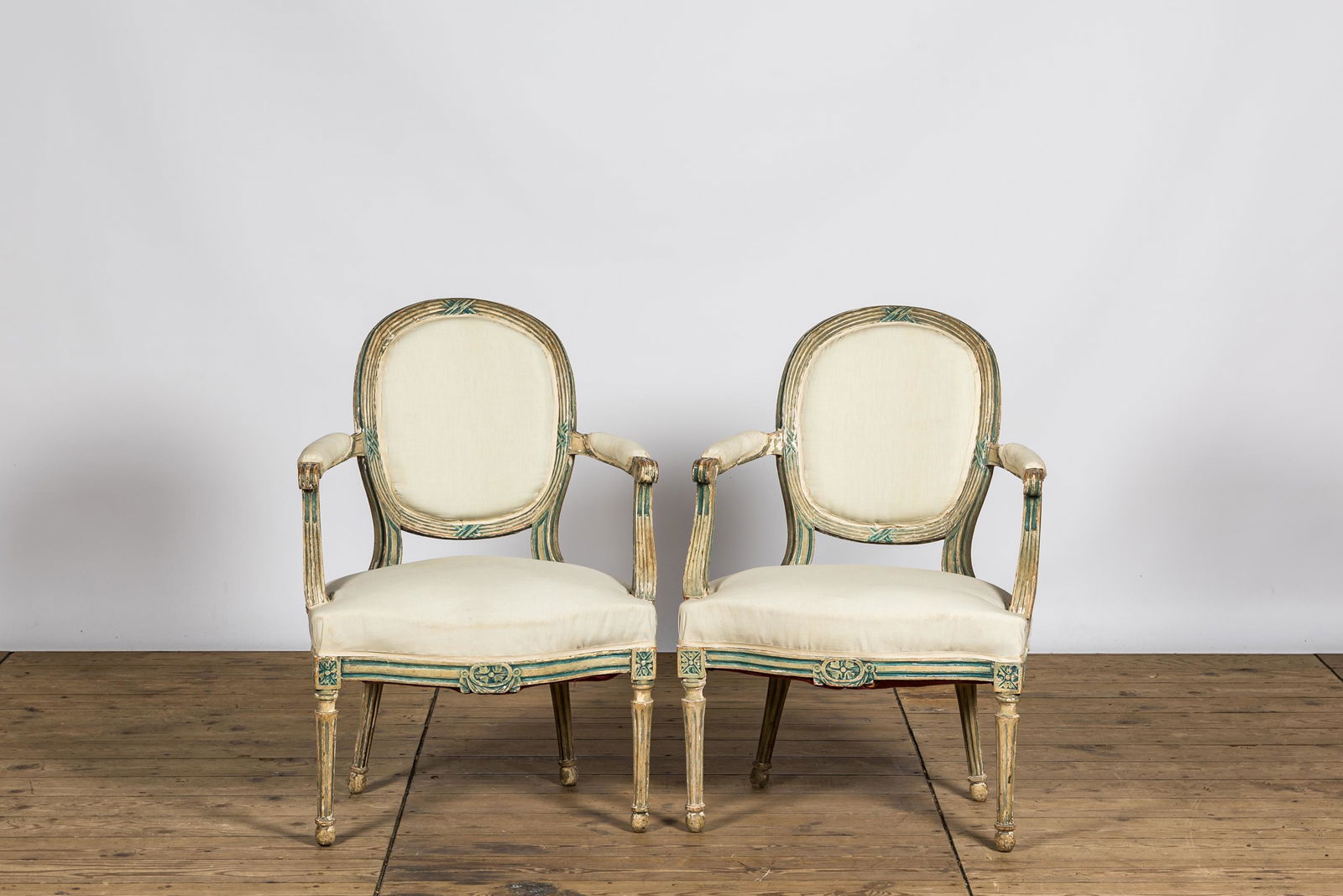 A pair of French white- and green-painted wooden armchairs, 19th C. (1 of 2)