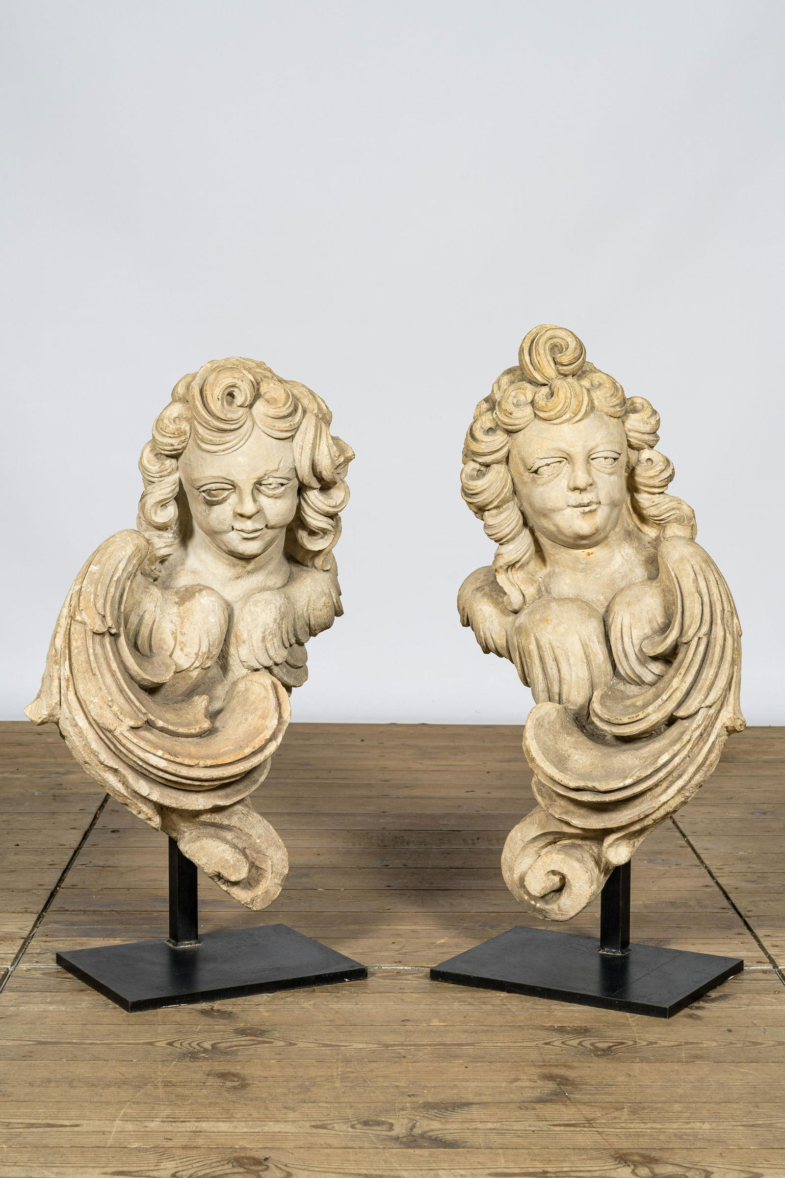 A pair of French limestone angel busts on a metal base, 18th C. (1 of 4)